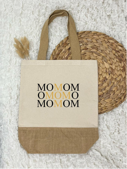 Auf dem Bild befindet sich eine Baumwolltasche, Jutetasche mit mehrfacher Mom-Aufschrift.