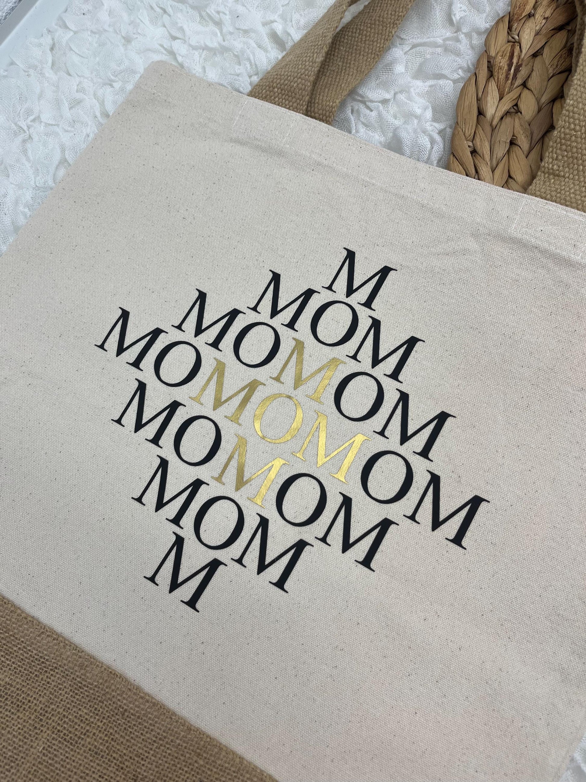 Auf dem Bild befindet sich eine Baumwolltasche, Jutetasche mit mehrfacher Mom-Aufschrift.