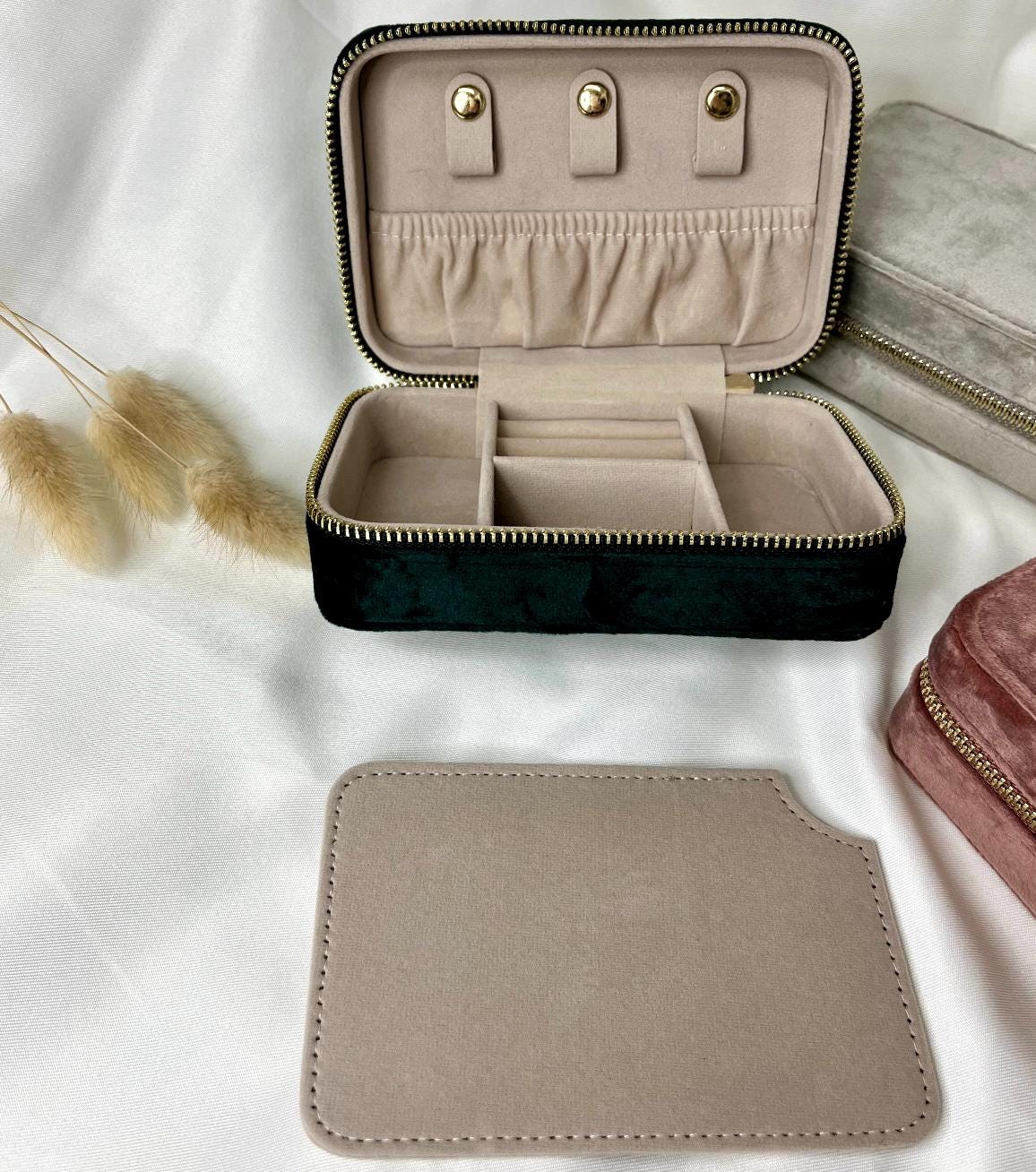 Sichere dir deine personalisierte Schmuckaufbewahrung aus 100 % recyceltem Polyester-Samtgewebe. Erhältlich in den Farben Dark Emerald, Moonstone und Rose Quartz, kannst du dein Etui mit deinem Namen personalisieren. Das kompakte Etui (15 x 10 x 5,9 cm) bietet Platz für Ringe, Ohrringe und Halsketten, mit Fächern, Haken und Samtfutter zum Schutz vor Kratzern. Der Reißverschluss und die Schieber sind goldfarben. Ein stilvolles und nachhaltiges Accessoire für deine Schmuckaufbewahrung.